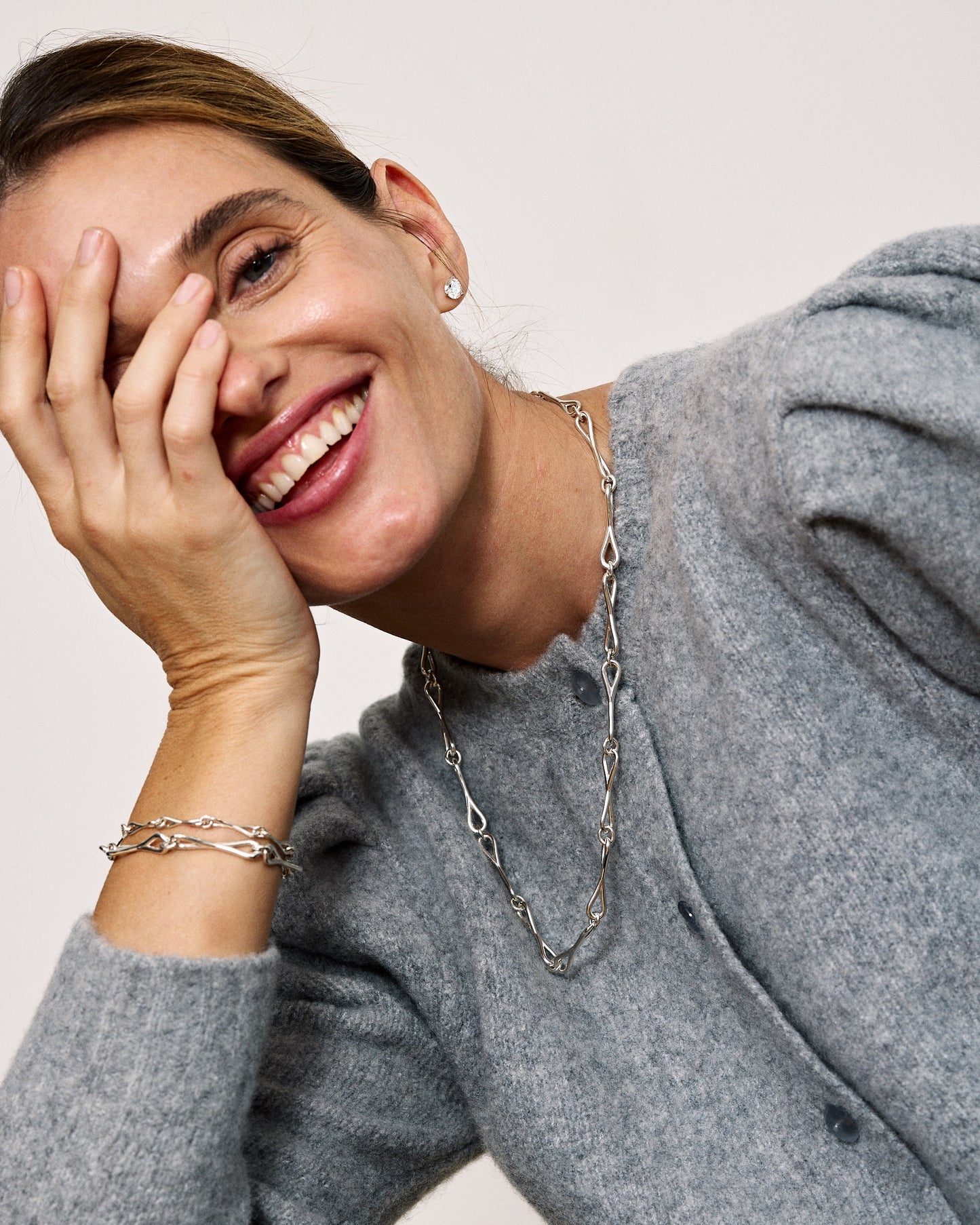 A model wearing a larrge WaterDrop link necklace and multiple WaterDrop link bracelets in sterling silver
