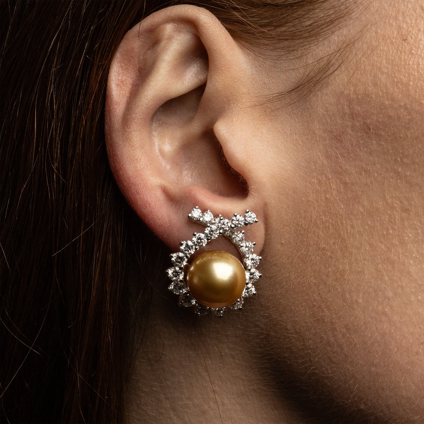 Vintage Angela Cummings for Assael earrings featuring round Golden South Sea cultured pearls surrounded by brilliant-cut diamonds in platinum and 18K white gold, shown on model. Offered by Roseate.