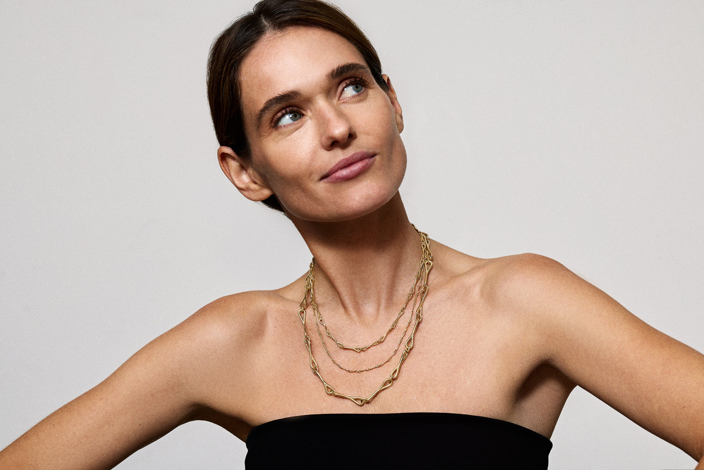 Multiple WaterDrop link necklaces in gold worn on a model