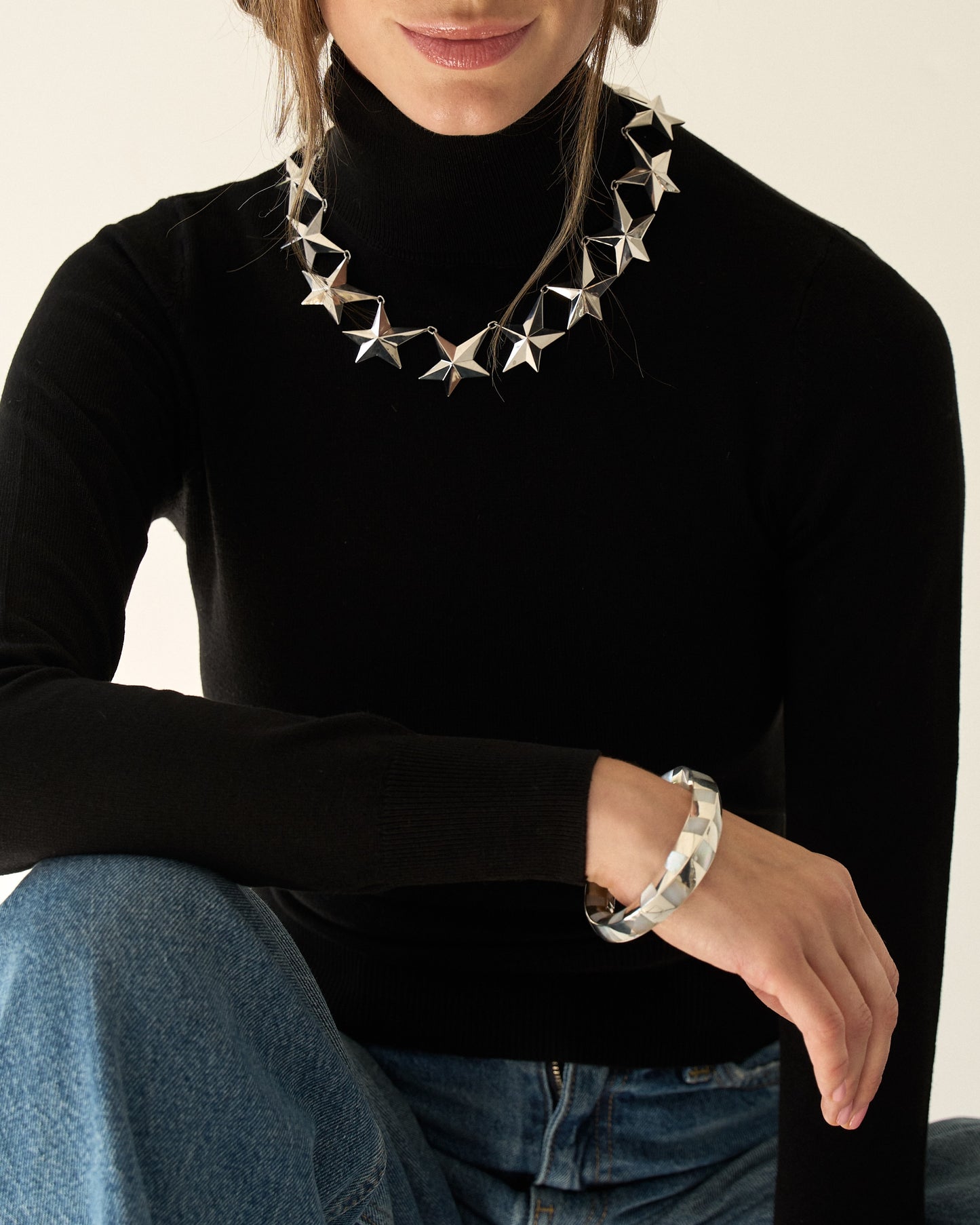 Angela Cummings large Star necklace in sterling silver shown on neckline and paired with mother-of-pearl checkerboard bangle