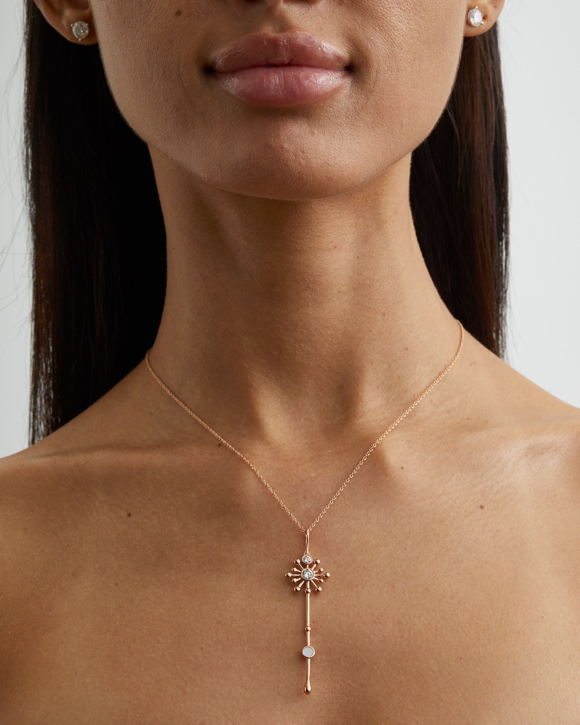 Light Wand Pendant in 18K yellow gold with luminous mother-of-pearl on a chain worn on a model