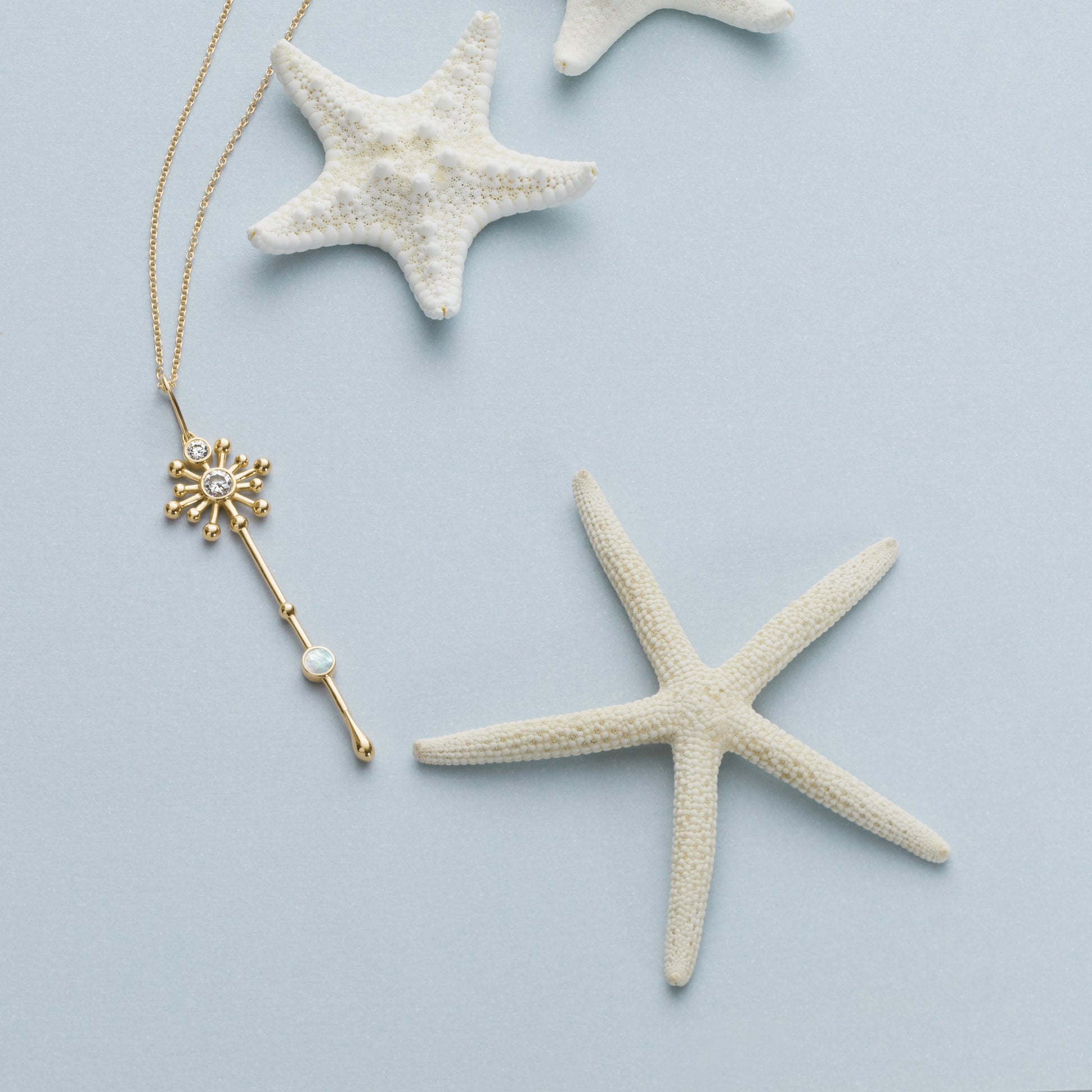 Light Wand Pendant in 18K yellow gold with luminous mother-of-pearl arranged with natural shells and a starfish
