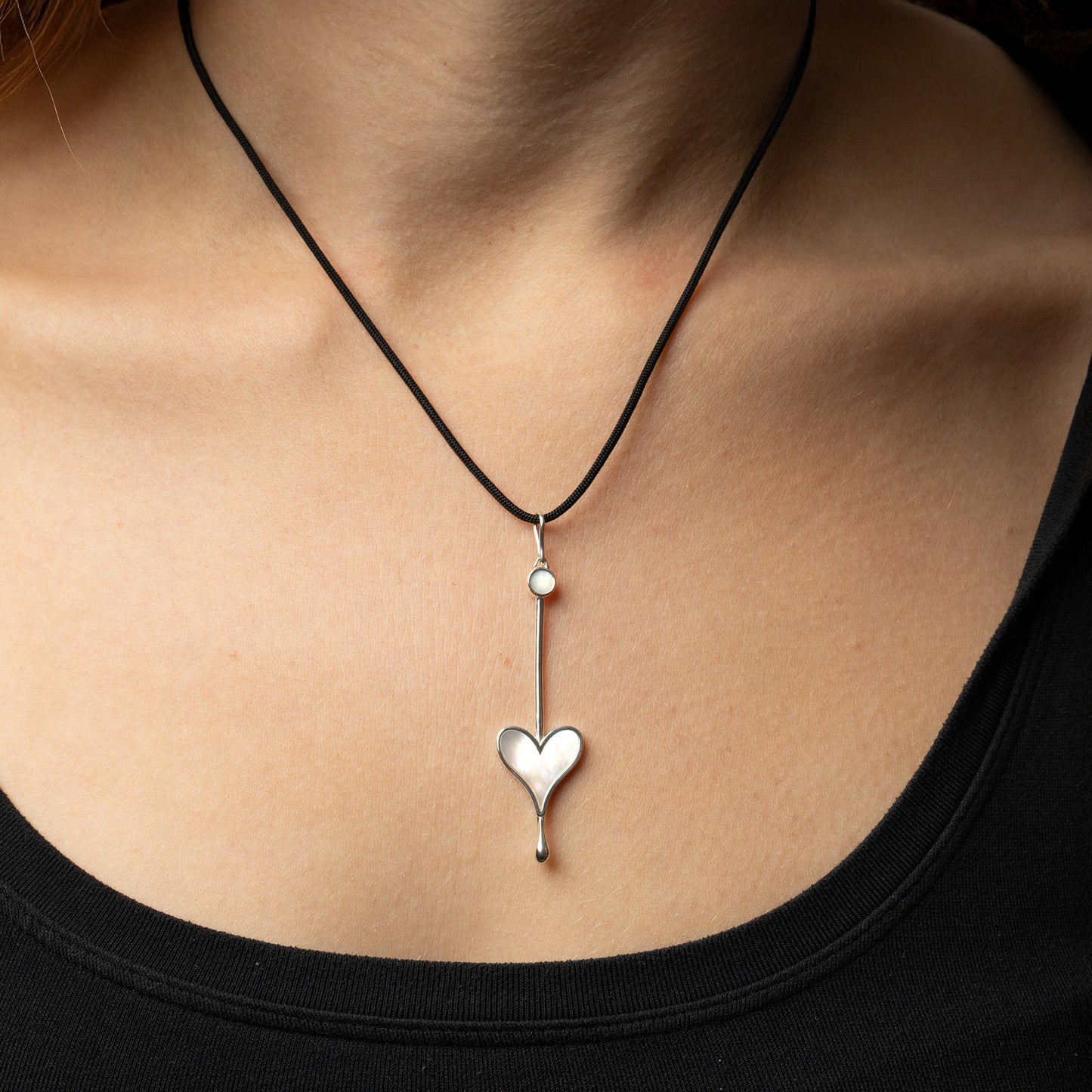 Sterling silver Love Wand pendant with luminous mother-of-pearl worn on a silk cord on a model