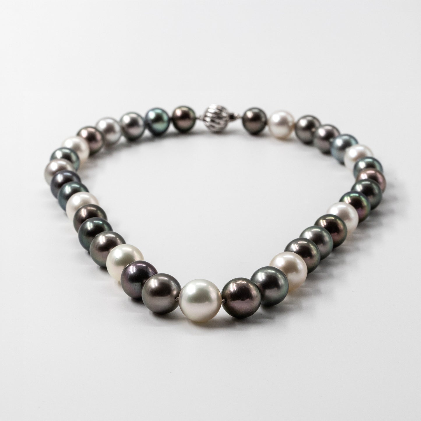 Multicolor necklace featuring genuine Tahitian and White South Sea cultured pearls with peacock, silver, charcoal, and white overtones, finished with an 18k white gold clasp