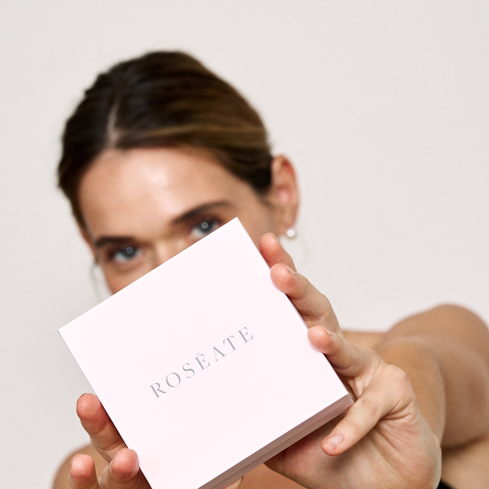 A model holding an iconic Rosate pink box