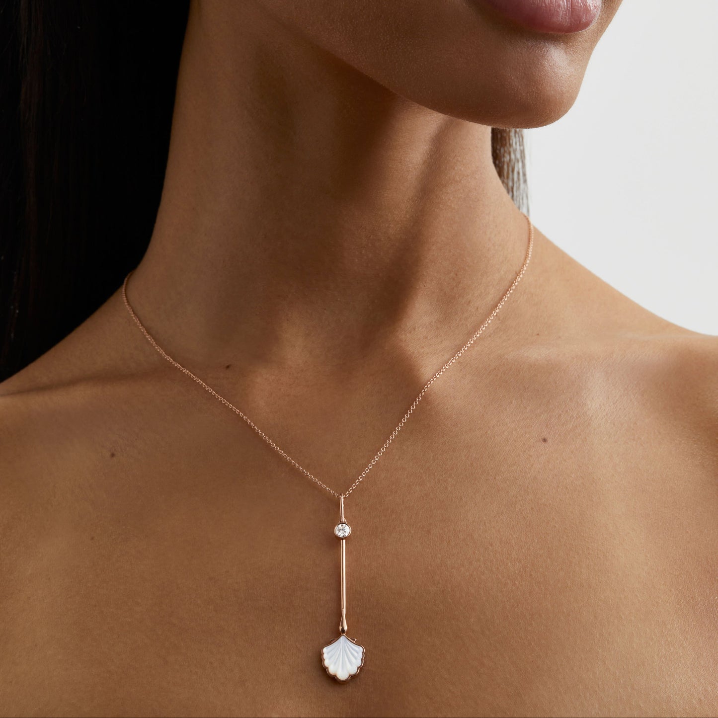 Roseate Water Wand pendant in 18k yellow gold with mother-of-pearl worn on a model