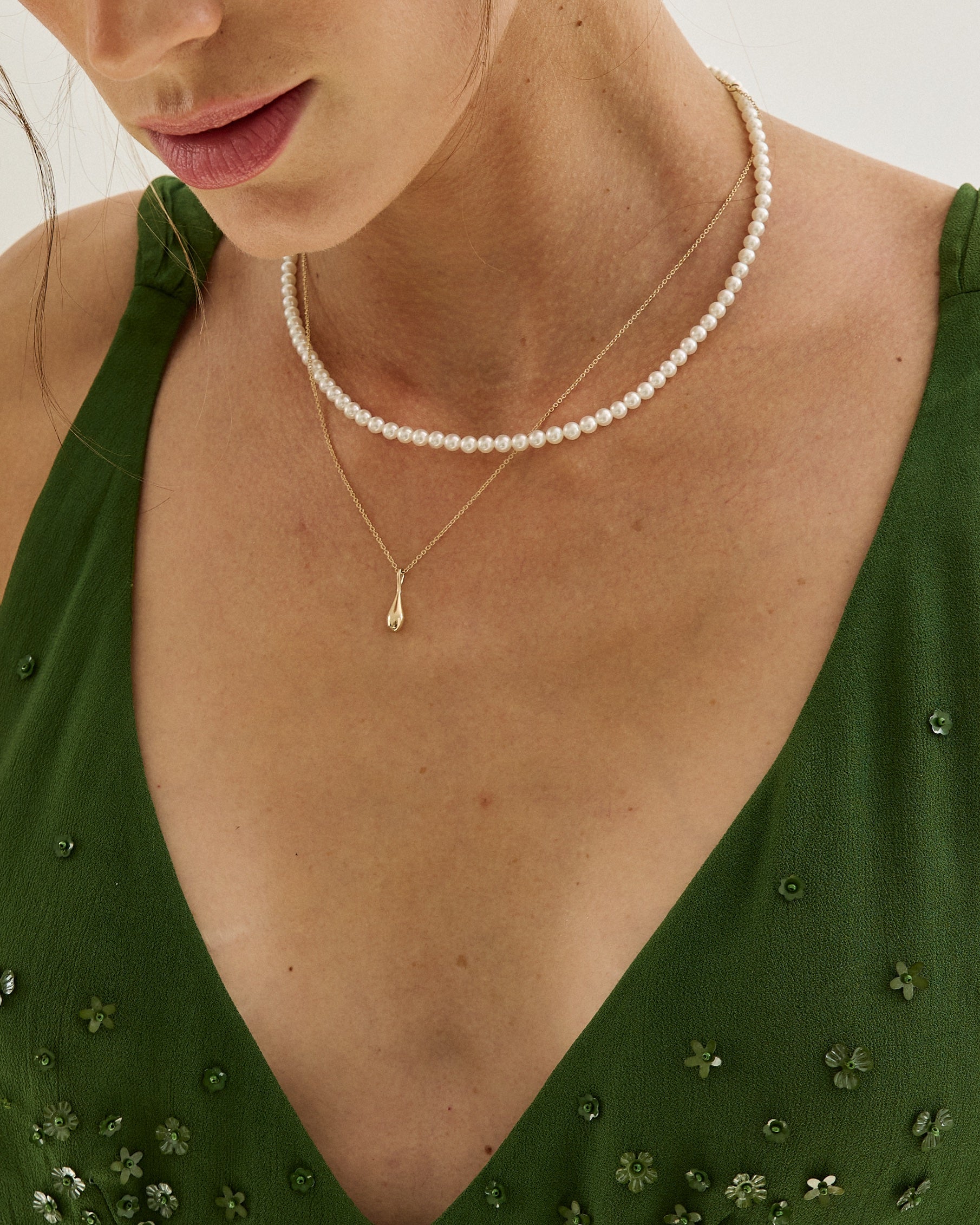 Roseate WaterDrop small pendant in 14k yellow gold with mother-of-pearl worn on a model