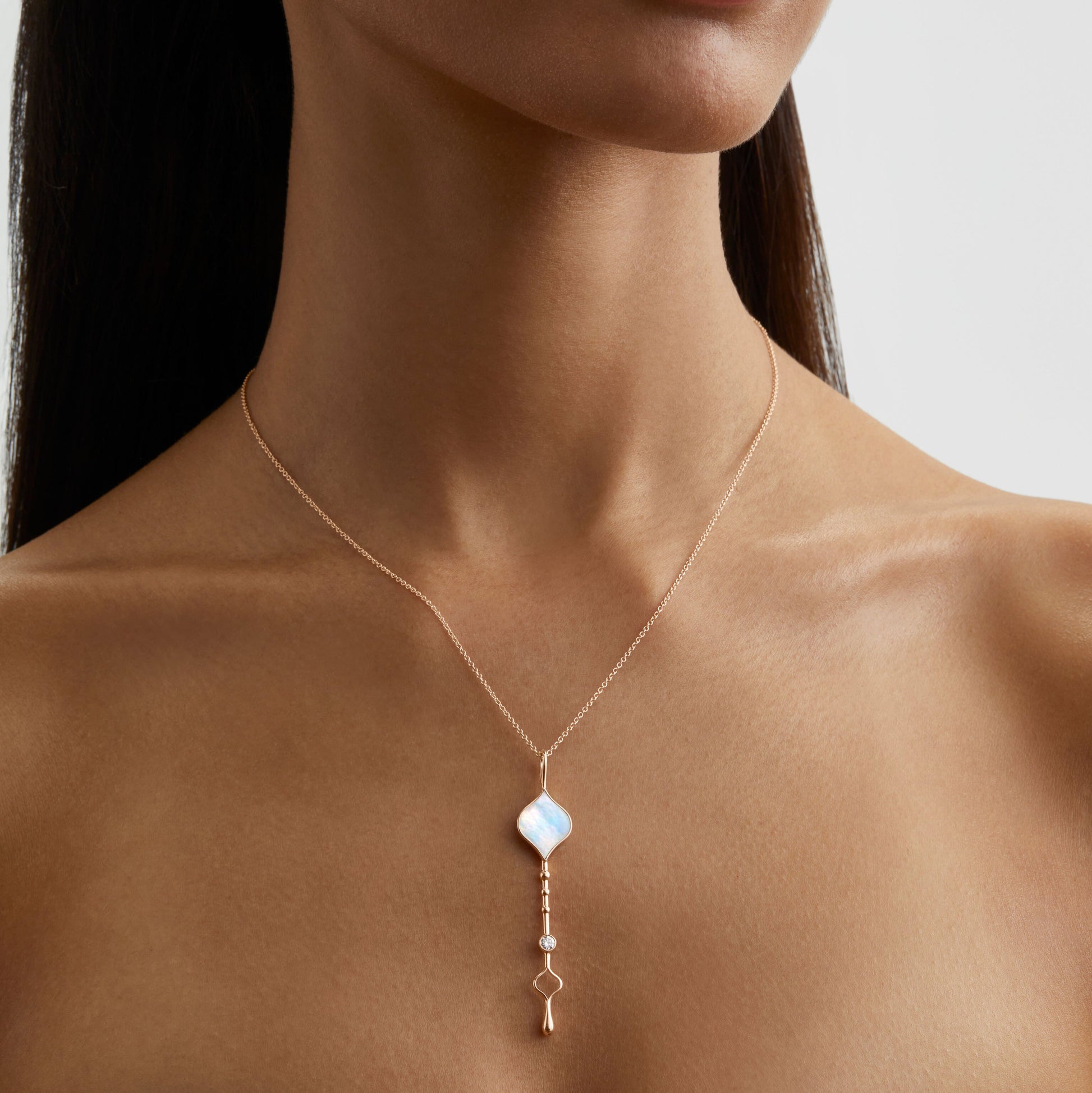 Unity Wand Pendant in 18K rose gold with luminous mother-of-pearl worn on a model