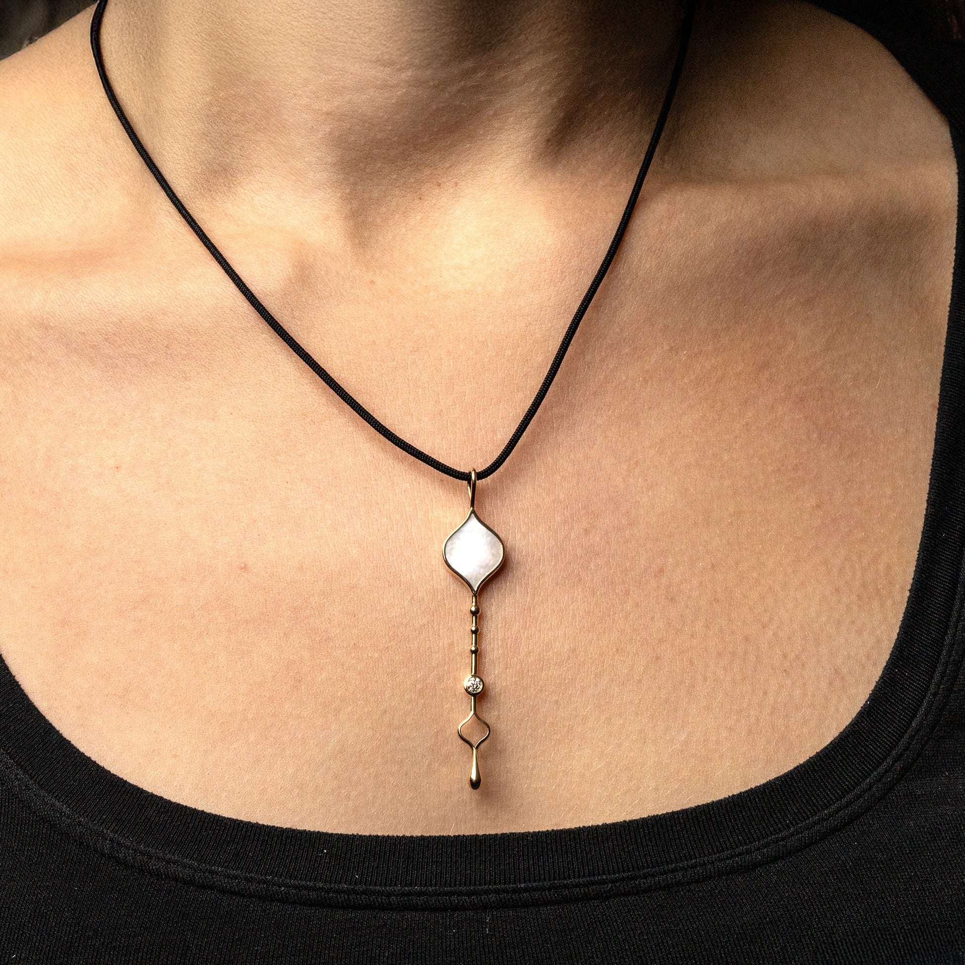 Unity Wand Pendant in 18K rose gold with luminous mother-of-pearl on a silk cord on model
