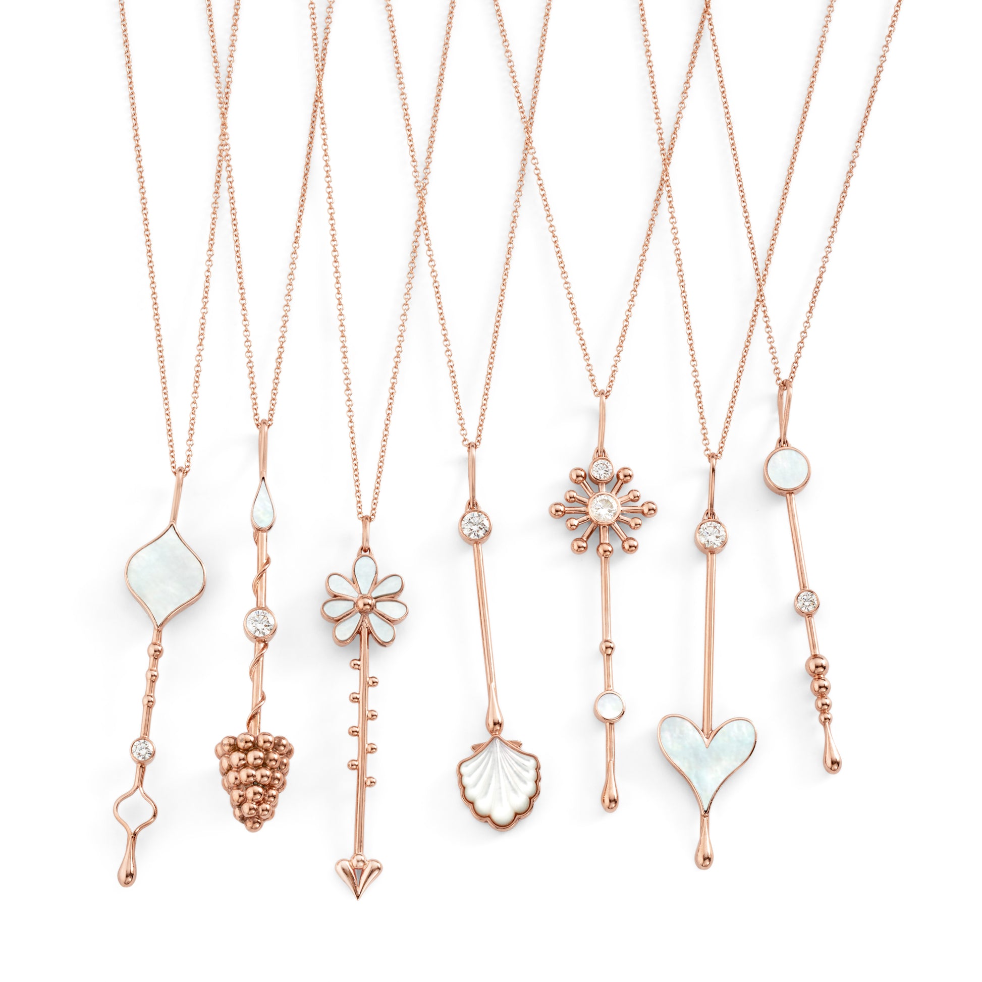 Multiple Love Wand pendants in rose gold with mother-of-pearl, displayed on chains against a clean white background