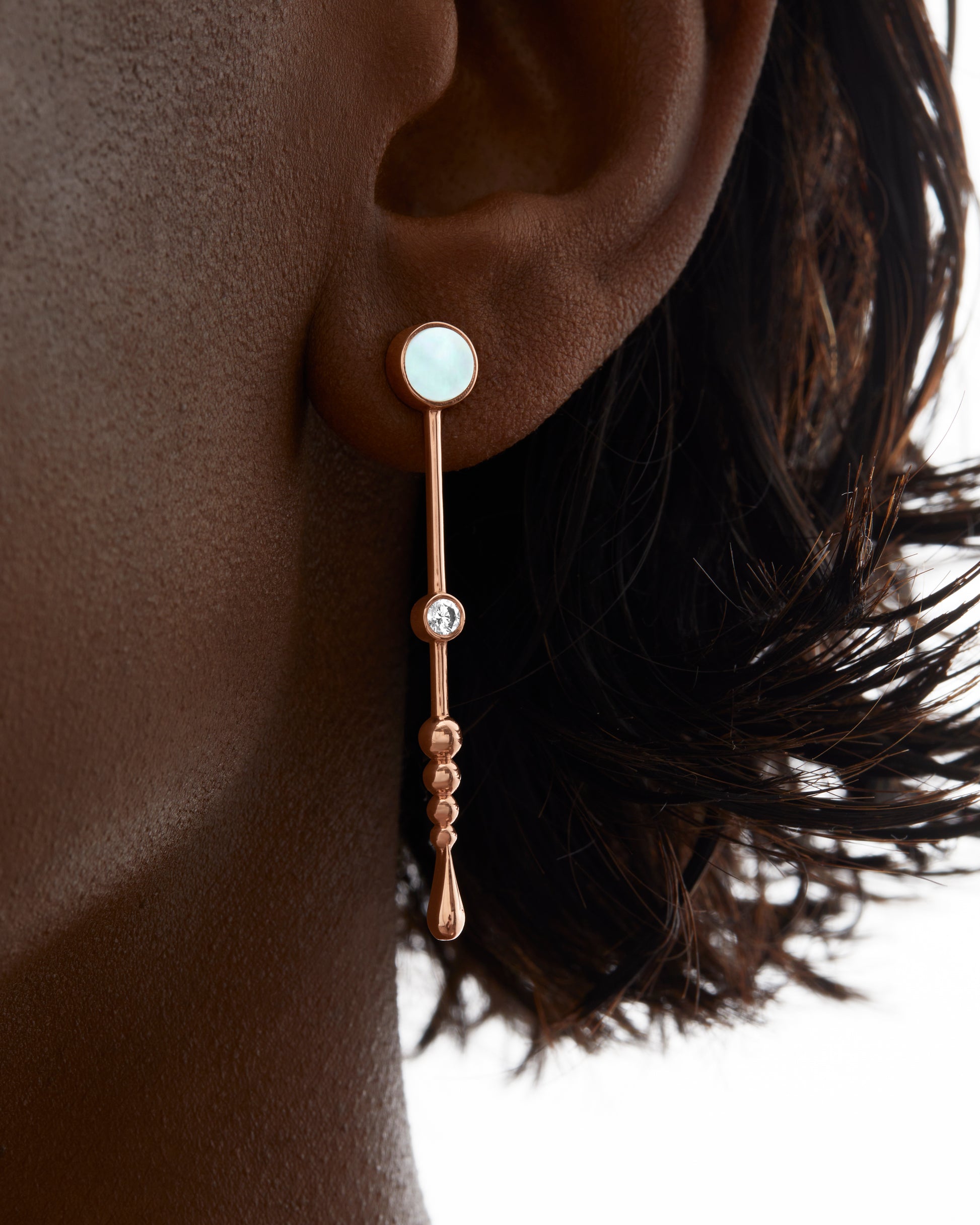 Roseate Loyalty Wand earrings in 18k rose gold with mother-of-pearl worn on a model