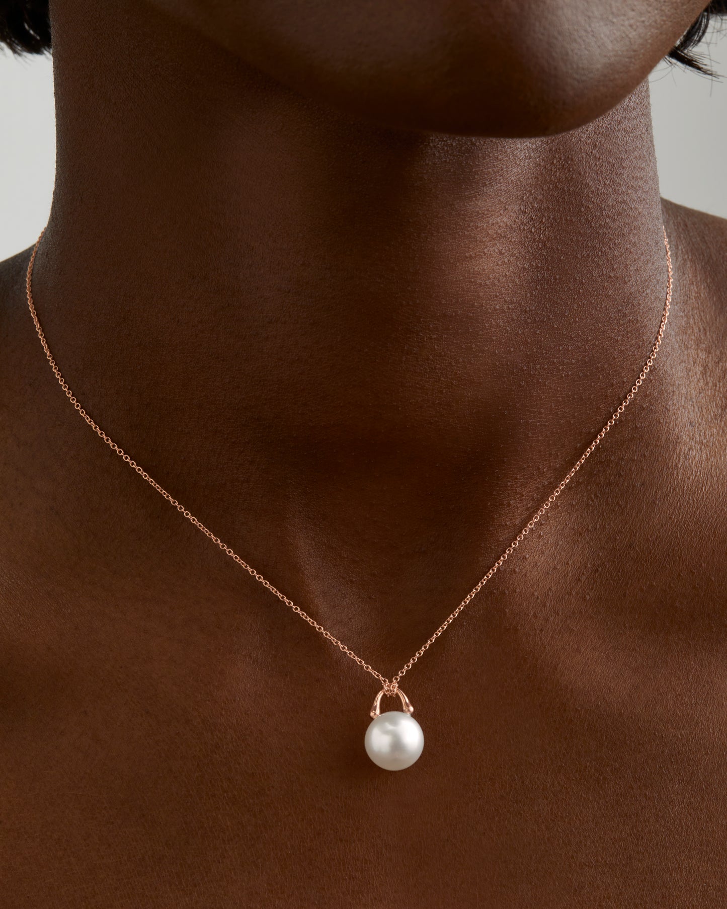 Roseate TreasureLock pendant featuring an 9mm white South Sea cultured pearl set in 18K rose gold. Shown on a model. A modern heirloom designed to showcase the exceptional beauty of a single South Sea pearl.